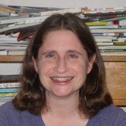 Laura Gehl portrait with a background of piles of books.