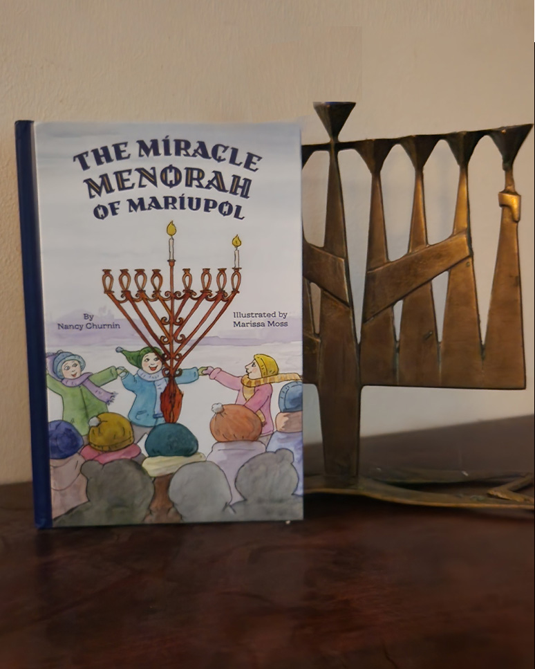 My copy of The Miracle Menorah of Mariupol with my menorah.